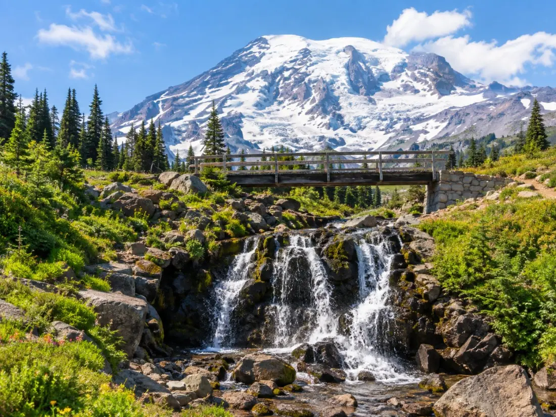 Myrtle Falls spilling over dark rock below a snowy Mount Rainier